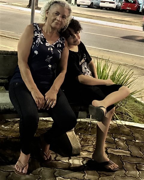 A Célia e o João sentados juntos num banco de praça à noite
